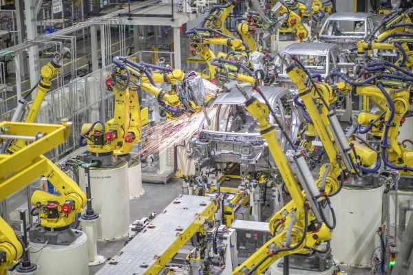 金康赛力斯两江智能工厂焊装车间,点焊机器人在对车身线进行焊接作业