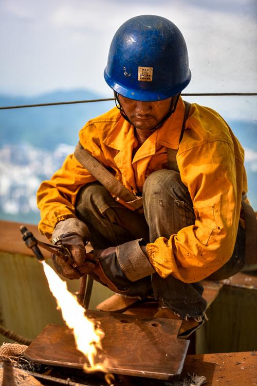 7月2日,工人在平安金融中心项目工地楼顶进行钢结构焊接作业.